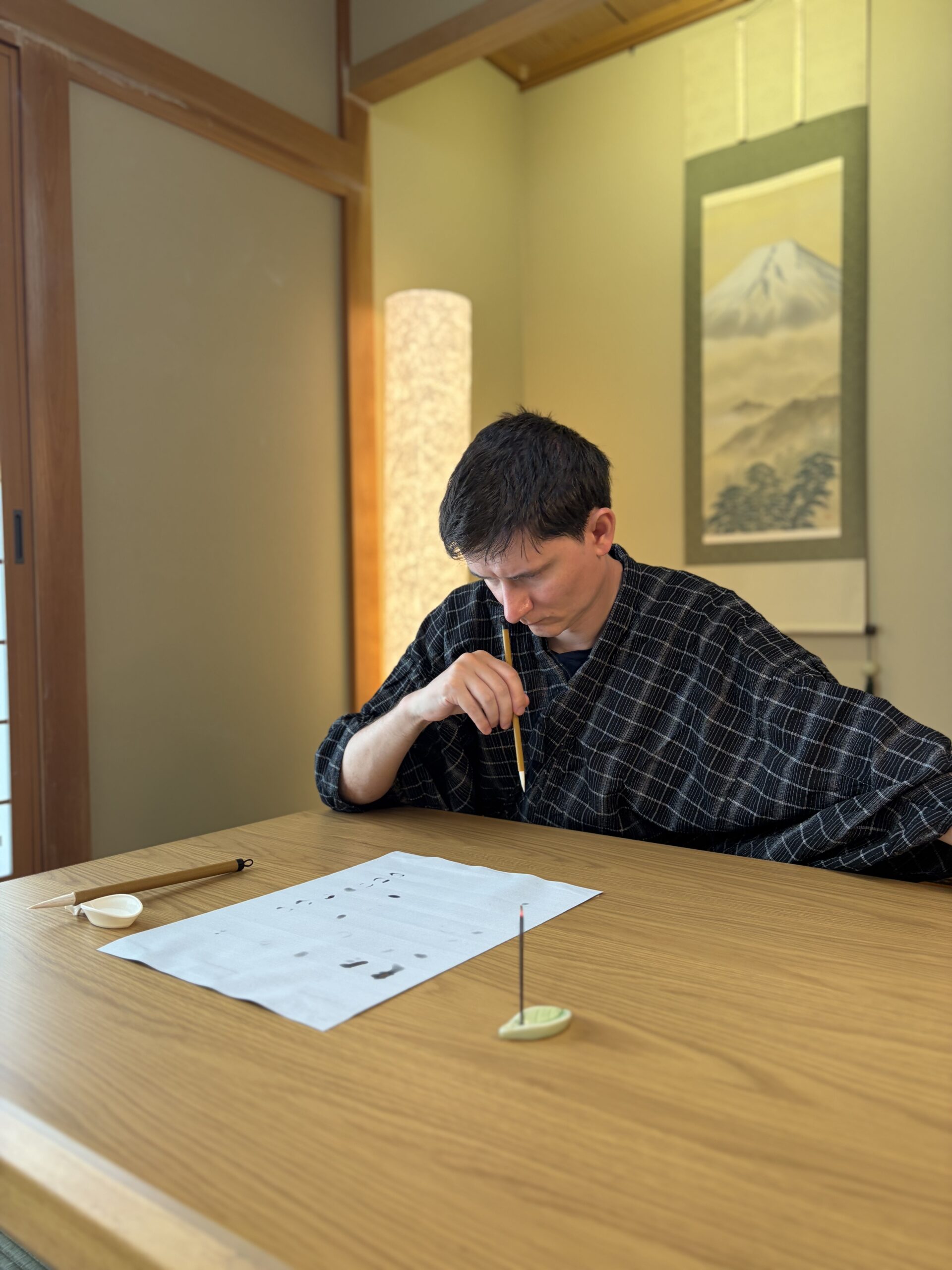 Writing with a water brush at a low wooden table